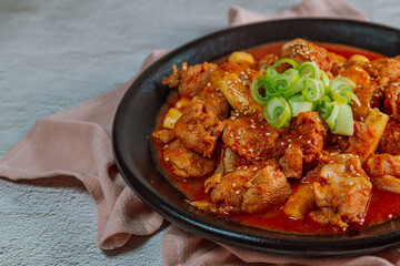 Korean food Spicy Stir-fried Chicken tteokbokki dish on black plate