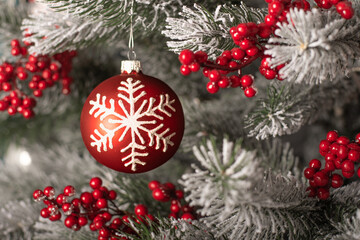 christmas tree red ball on the background of spruce branches. High quality photo. white snowflake on the christmas tree red toy