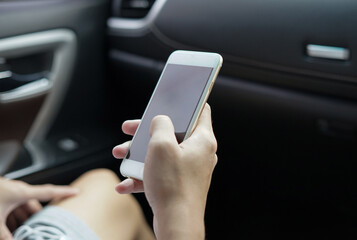 man hands using smartphone in a car, soft focus.
