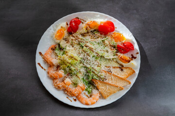 Caesar salad dish with shrimp lettuce and cherry tomatoes