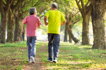 Rear view of Senior couple in face mask and jogging in the park