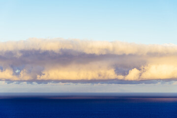 Trade Winds clouds reflected on the ocean at sunset. The trade winds or easterlies are the permanent east-to-west prevailing winds that flow in the Earth equatorial region