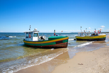Fishing boat by the sandy beach on the Baltic Sea on a sunny day, Sopot, Poland.