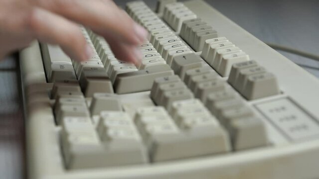Typing on old PC computer keyboard (close up)