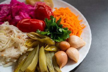 assorted pickled vegetables with cabbage and tomatoes with cucumbers on a plate