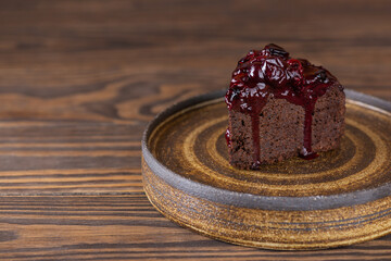 Chocolate cake with black currants on a plate. Sugar, gluten and lactose free and vegan. Horizontal orientation, copy space.