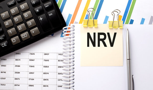 NRV text, written on a sticker with calculator,pen on chart background.