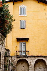 Orange facade of an old house with arches. Bergamo, Italy