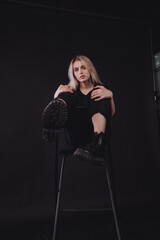 blonde girl in the studio on a black background in black clothes