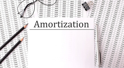 Paper with AMORTIZATION on a table with chart and pencils