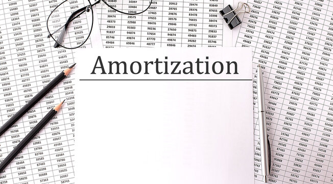 Paper with AMORTIZATION on a table with chart and pencils