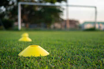 Football training cone for speed and moving practice is placed on firm ground pitch. Sport...