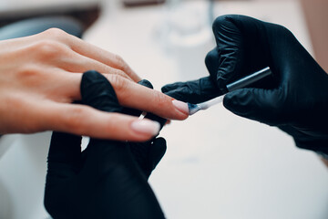 Manicure process female hands finger nails varnish polish.