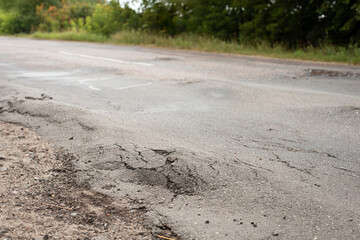 Uneven road surface in the countryside. Road in bad condition