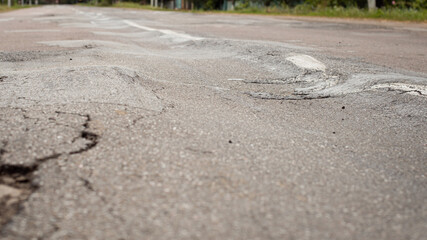 Uneven surface of asphalt road. Road in terrible condition