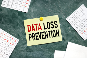 DATA LOSS PREVENTION. blank yellow sticker on a green chalk board attached by a round magnet, place...
