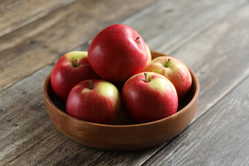 red apples in a bowl in a wooden table
