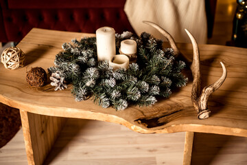 a solid wood wooden table in the living room by the sofa and a Christmas tree with candles on it.