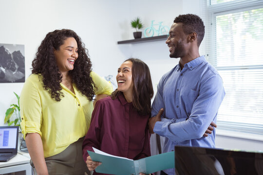 Happy diverse group of business people working together, discussing work in modern office