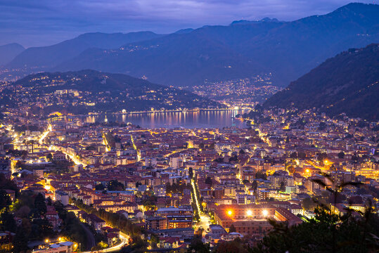  The city of Como, and the lake, photographed after sunset, with the mountains of Brunate, Castel Baradello, and the mountains overlooking the lake.
