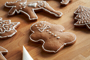 Fototapeta na wymiar Decorating homemade gingerbread Christmas cookies using a cornet