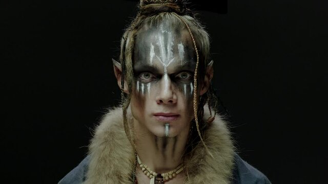 Sharp eared elf with makeup in tribal clothes on black
