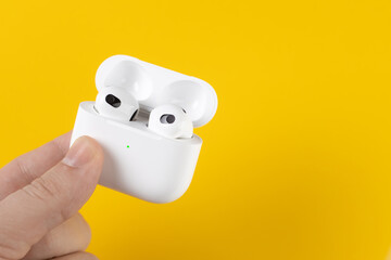 White wireless headphones on a yellow background. Bright background. air pods 3