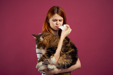 woman holding fluffy cat in her arms pet friendship pink background