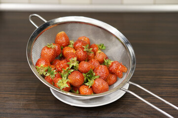 Closeup shot of fresh whole strawberries in a fine mesh strainer
