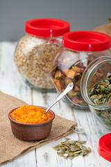 Dry pumpkin seeds in a glass jar on a white wooden board