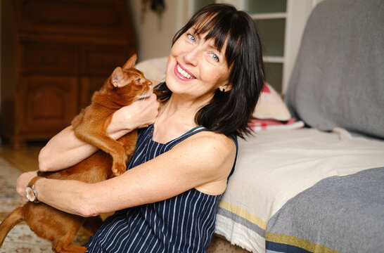 Woman caressing with domestic Abyssinian cat
