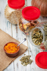 Dry pumpkin seeds in a glass jar on a white wooden board