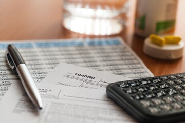 Calculator, Pen, Pills and Tax Forms