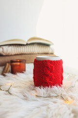 Red knitted cup with a drink on a Christmas background. New Year's home comfort