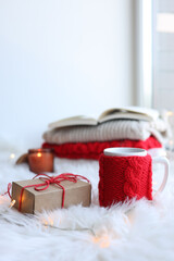 Red knitted cup with a drink on a Christmas background. New Year's home comfort