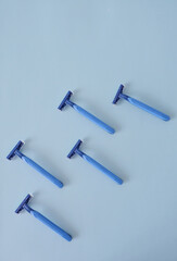 Composition of blue disposal plastic razors in a light blue background