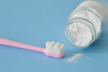 Plastic superfine micro-nano tooth brush and baking soda jar on a blue background