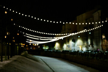 Abstract blurred background with bokeh colorful circles. City lifestyle backdrop made with street lamps and garland lights