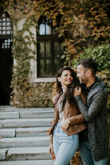 Young couple standing by the stairs in autumn park