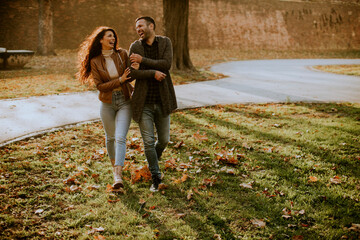 Fototapeta premium Young couple walking in autumn park