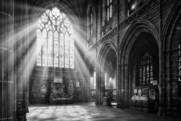 a large cathedral with sun rays coming through a stained glass window