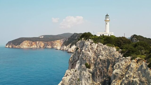 Aerial drone view of the Ionian Sea coast of Zakynthos, Greece. Rocky ridge with lighthouse and sparce vegetation, blue water