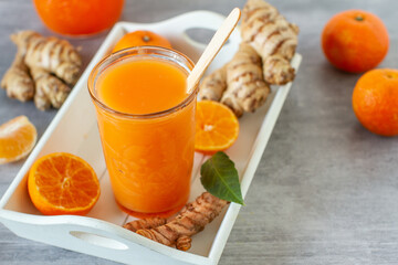 Winter smoothie with ginger, turmeric and  tangerine  - obrazy, fototapety, plakaty