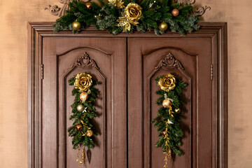Fototapeta na wymiar Beautiful Christmas door with a Christmas tree and golden balls. Christmas home interior