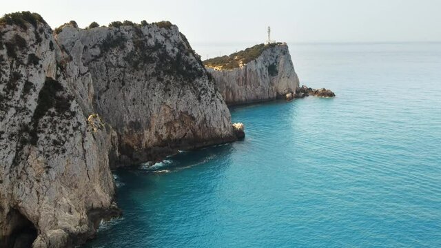 Aerial drone view of the Ionian Sea coast of Zakynthos, Greece. Rocky ridge with lighthouse and sparce vegetation, blue water
