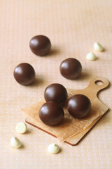 Chocolate Glazed Cake Pops without stick, on light yellow background.