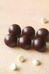 Chocolate Glazed Cake Pops without stick, on light yellow background.