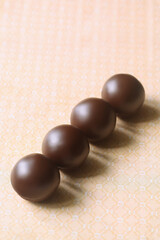 Chocolate Glazed Cake Pops without stick, on light yellow background.