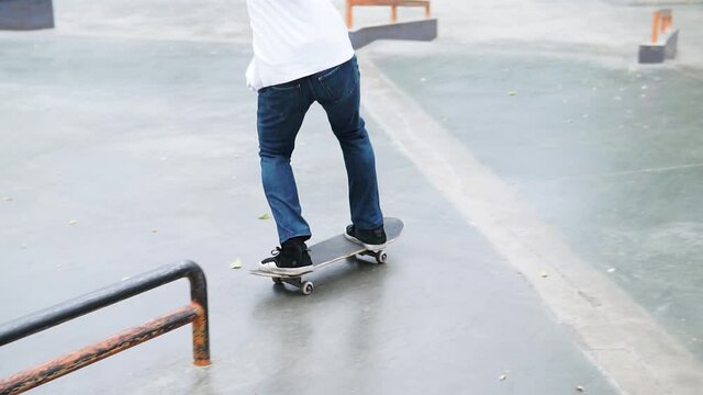 Skater practicing in skate park, making tricks.sliding on board on long railing
