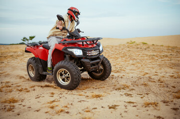 An atv rider racing in desert